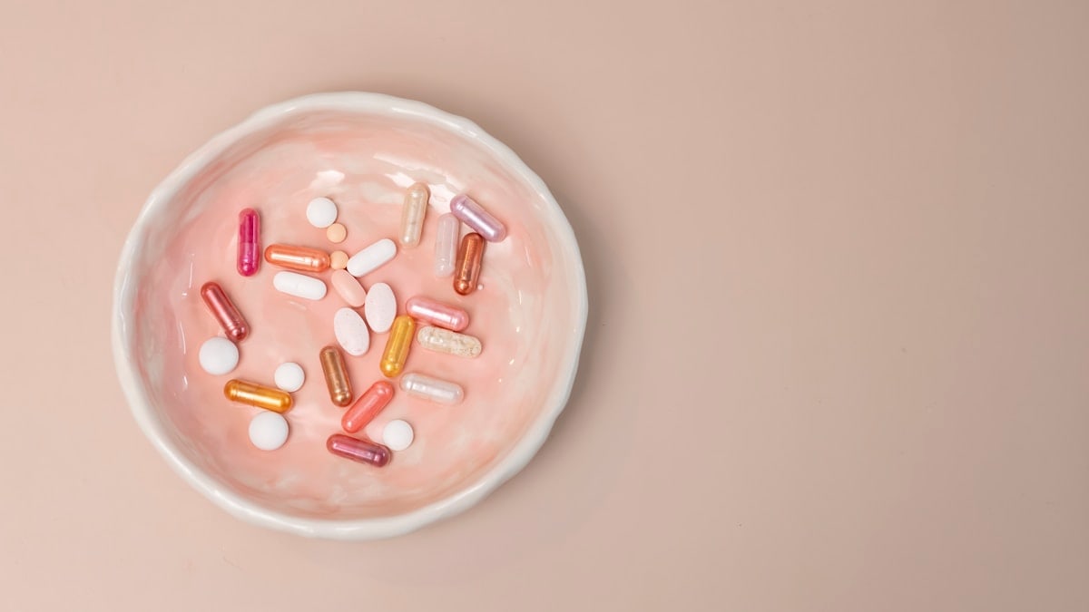 A white bowl filled with pills on top of a table
